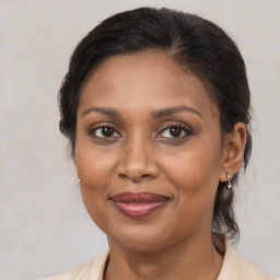 Joyful black adult female with medium  brown hair and brown eyes