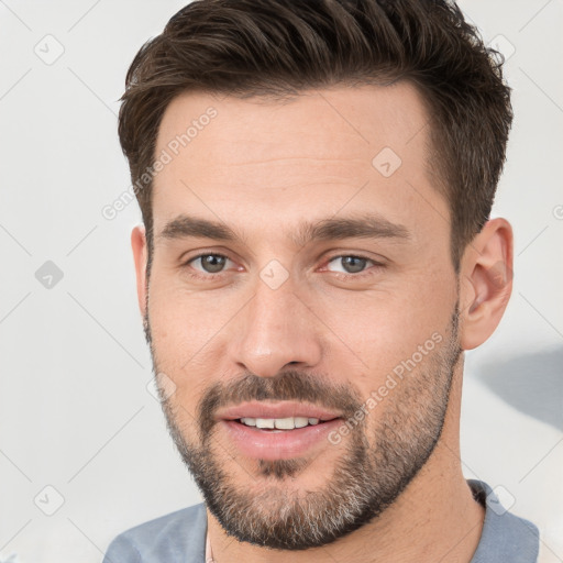 Joyful white young-adult male with short  brown hair and brown eyes