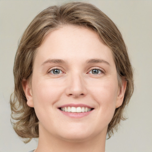 Joyful white young-adult female with medium  brown hair and green eyes