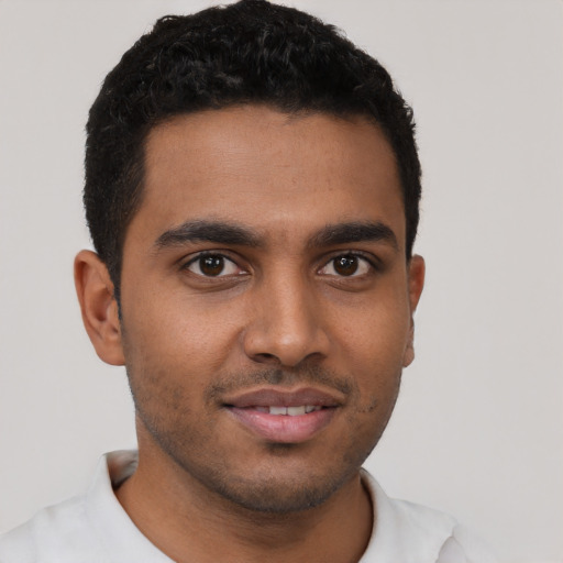 Joyful black young-adult male with short  brown hair and brown eyes