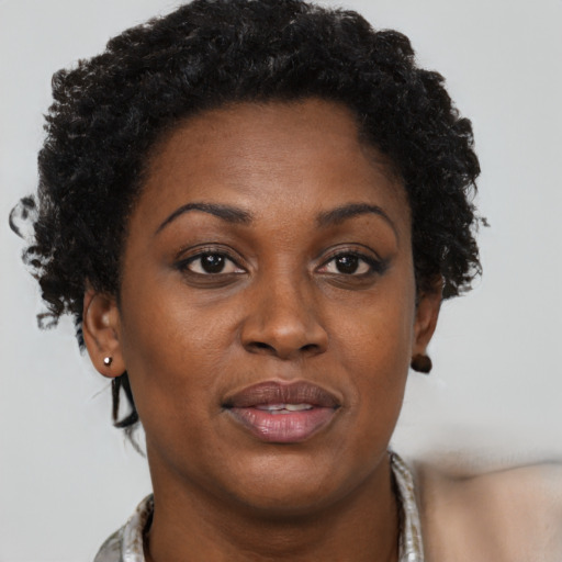 Joyful black adult female with short  brown hair and brown eyes