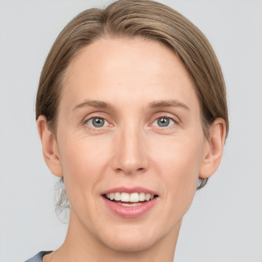 Joyful white adult female with medium  brown hair and grey eyes