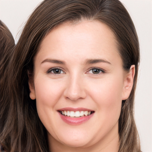 Joyful white young-adult female with long  brown hair and brown eyes