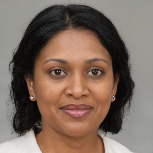 Joyful black adult female with medium  brown hair and brown eyes