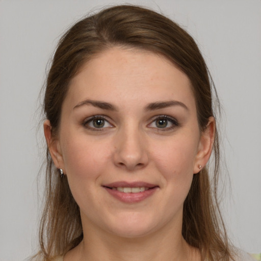 Joyful white young-adult female with long  brown hair and grey eyes