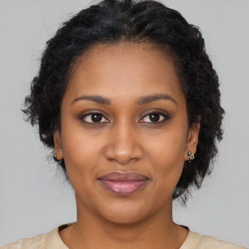 Joyful black young-adult female with long  brown hair and brown eyes