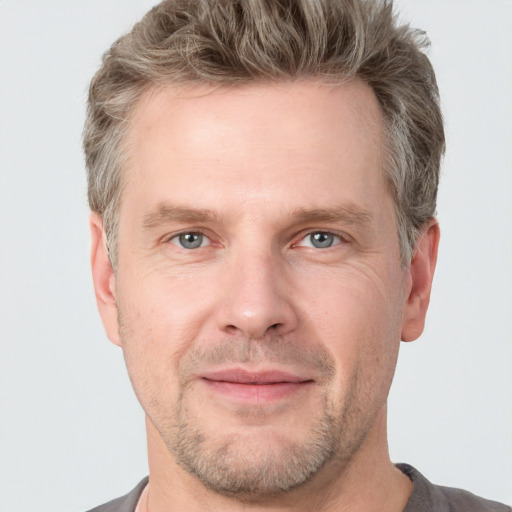 Joyful white adult male with short  brown hair and grey eyes