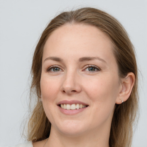 Joyful white young-adult female with medium  brown hair and grey eyes