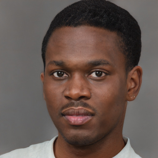 Joyful black young-adult male with short  brown hair and brown eyes