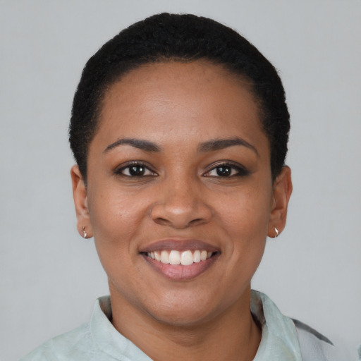 Joyful black young-adult female with short  black hair and brown eyes