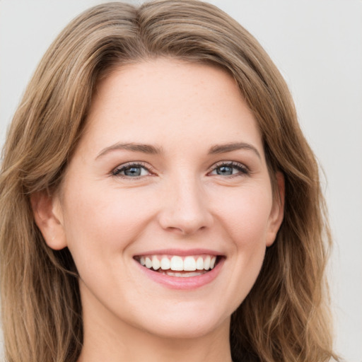 Joyful white young-adult female with long  brown hair and green eyes