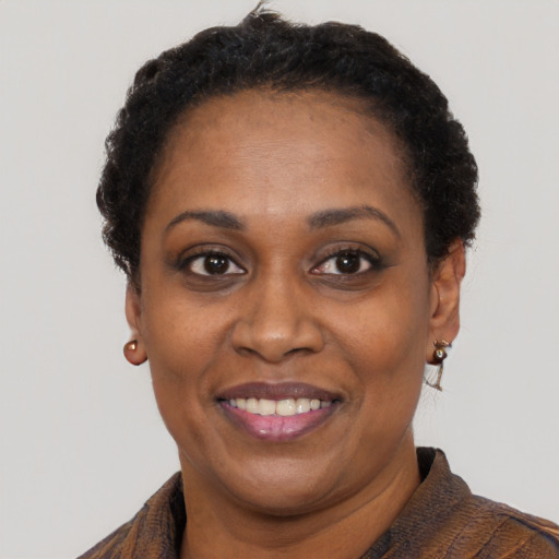 Joyful black adult female with short  black hair and brown eyes
