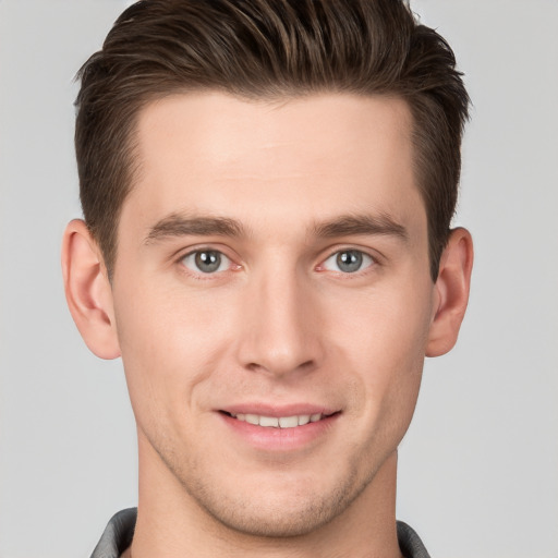 Joyful white young-adult male with short  brown hair and grey eyes