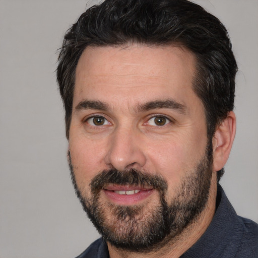 Joyful white adult male with short  black hair and brown eyes