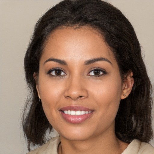 Joyful latino young-adult female with medium  brown hair and brown eyes