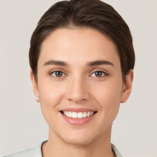 Joyful white young-adult female with short  brown hair and brown eyes