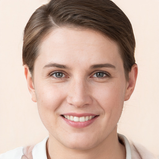 Joyful white young-adult female with short  brown hair and grey eyes