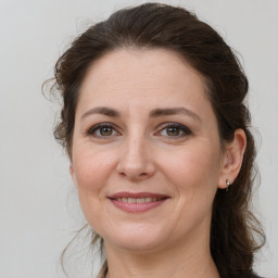 Joyful white adult female with medium  brown hair and grey eyes