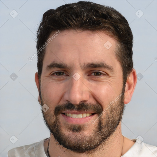 Joyful white adult male with short  black hair and brown eyes