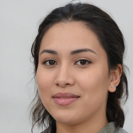 Joyful latino young-adult female with medium  brown hair and brown eyes