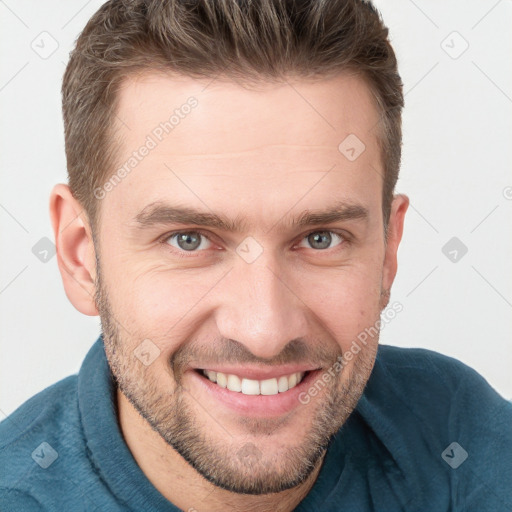 Joyful white young-adult male with short  brown hair and grey eyes