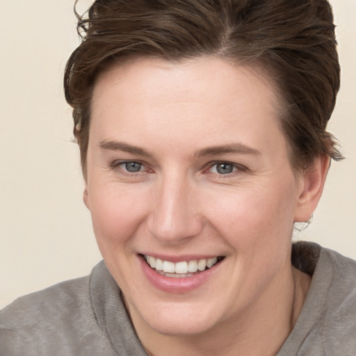 Joyful white young-adult female with short  brown hair and grey eyes