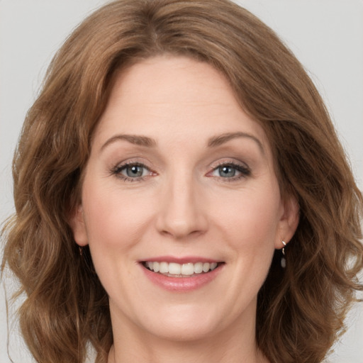 Joyful white young-adult female with medium  brown hair and green eyes