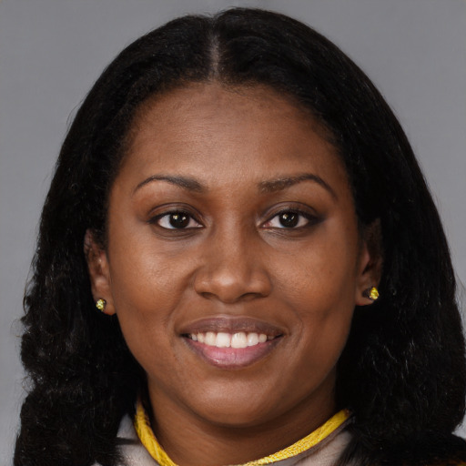 Joyful black young-adult female with long  brown hair and brown eyes