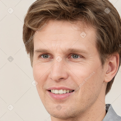 Joyful white adult male with short  brown hair and grey eyes