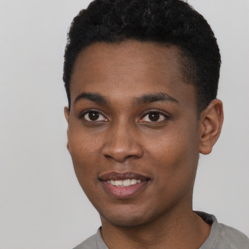Joyful black young-adult male with short  black hair and brown eyes