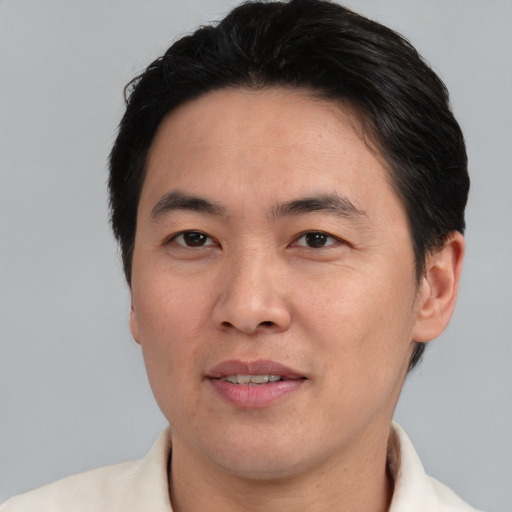 Joyful asian adult male with short  brown hair and brown eyes