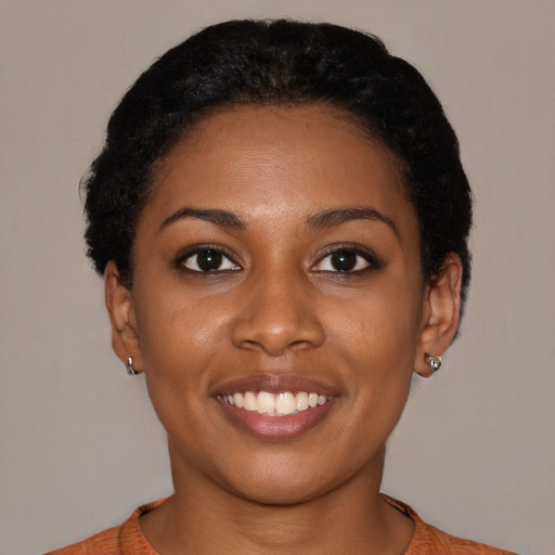 Joyful black young-adult female with short  black hair and brown eyes