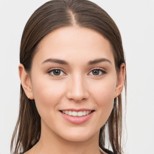 Joyful white young-adult female with long  brown hair and brown eyes