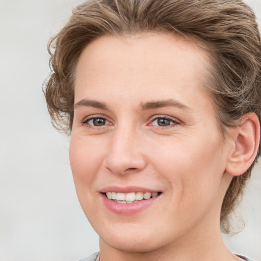 Joyful white young-adult female with medium  brown hair and blue eyes