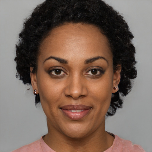 Joyful black adult female with short  black hair and brown eyes