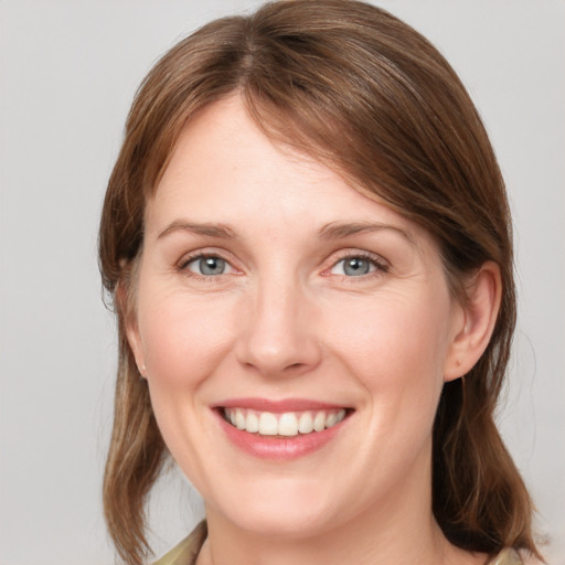 Joyful white young-adult female with medium  brown hair and blue eyes