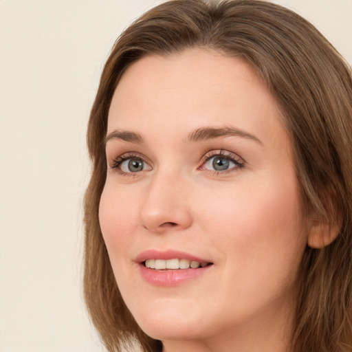 Joyful white young-adult female with long  brown hair and green eyes