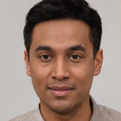 Joyful latino young-adult male with short  black hair and brown eyes