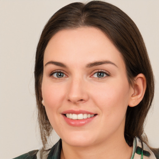 Joyful white young-adult female with medium  brown hair and green eyes