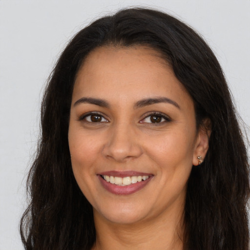 Joyful latino young-adult female with long  brown hair and brown eyes