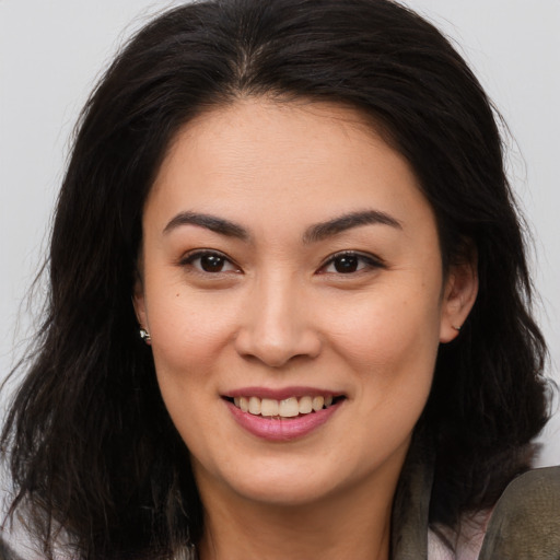 Joyful asian young-adult female with long  brown hair and brown eyes