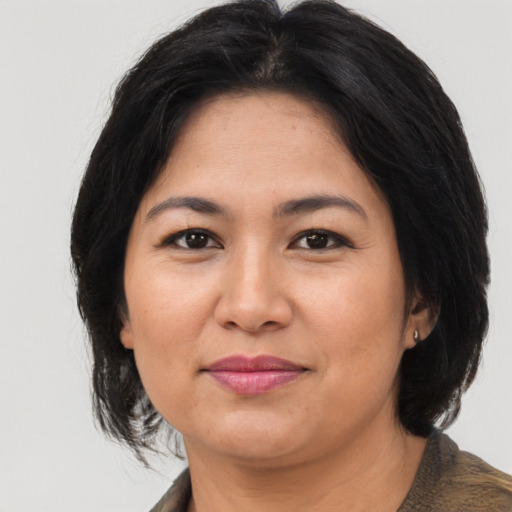 Joyful asian adult female with medium  brown hair and brown eyes