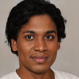 Joyful black young-adult male with short  brown hair and brown eyes