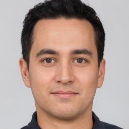 Joyful white young-adult male with short  black hair and brown eyes
