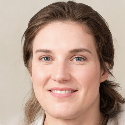 Joyful white young-adult female with medium  brown hair and blue eyes