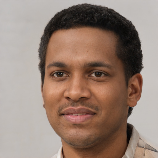 Joyful black young-adult male with short  black hair and brown eyes