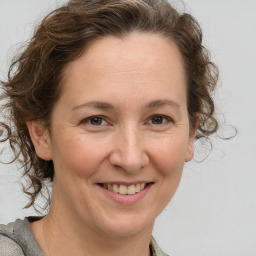 Joyful white adult female with medium  brown hair and brown eyes