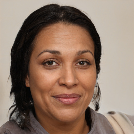 Joyful latino adult female with medium  brown hair and brown eyes