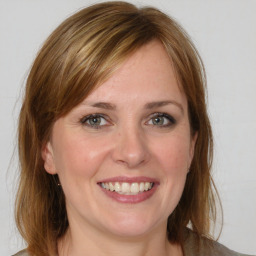 Joyful white young-adult female with medium  brown hair and grey eyes