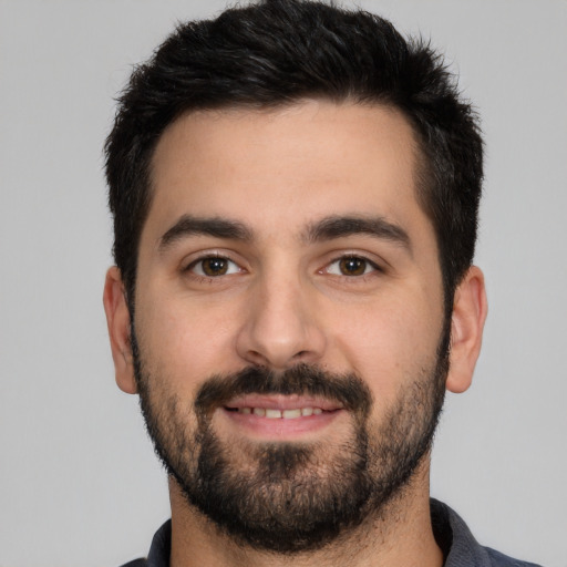 Joyful white young-adult male with short  black hair and brown eyes